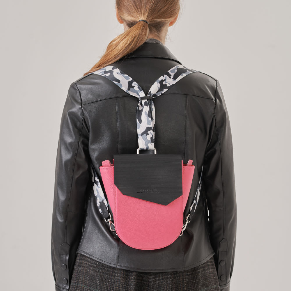 Mochila cuero fucsia granulado con tapa negra con broche imantado y cierre interior. Convertible en cartera. Realizado 100% en cuero vacuno combinando texturas lisas y cuero grabado.