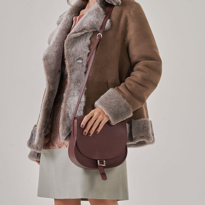 Cartera con correa de largo regulable, tapa con broche imantado. Bolsillito con cierre interior y portallaves.