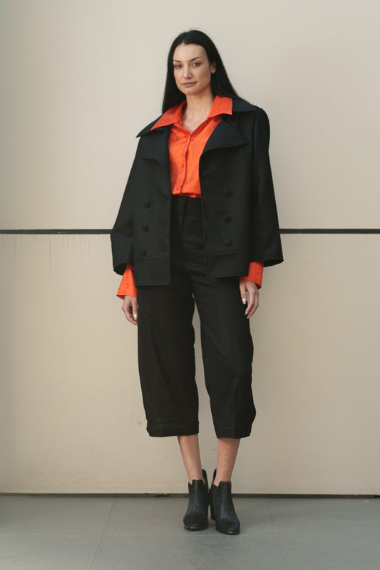 Diseño geométrico de calce amplio y talla unica, con fuerte influencia asiática. Cuello redondo, botonadura simple, aberturas en puños y bolsillos, tablón trasero. Paño 100% lana de Bellavista Tomé, forrada en rayón/viscosa de Strobel Linnings.