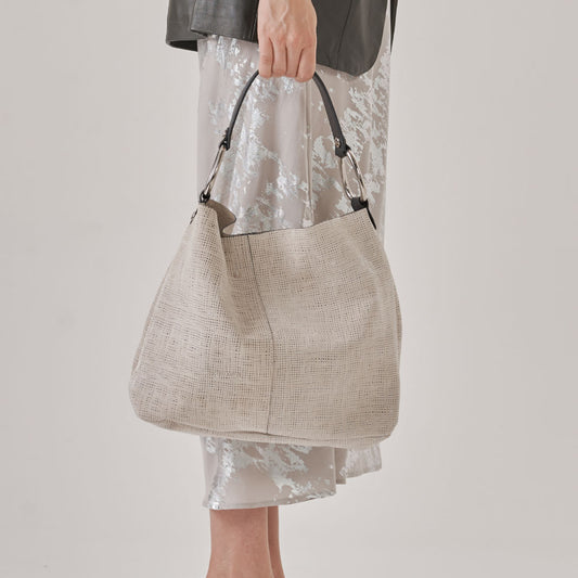 Bolso con herrajes ovalados, cuero graneado y correa que se adapta perfectamente al hombro. Billetera colgante (interior) y portallaves.
